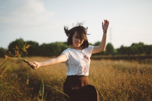 Girl spinning in field.