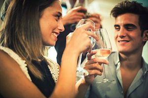 Man clinking glasses with woman at a party