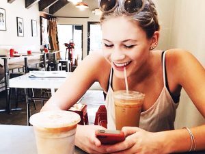 woman using Tinder in a coffeeshop