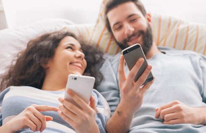 couple on phones in bed